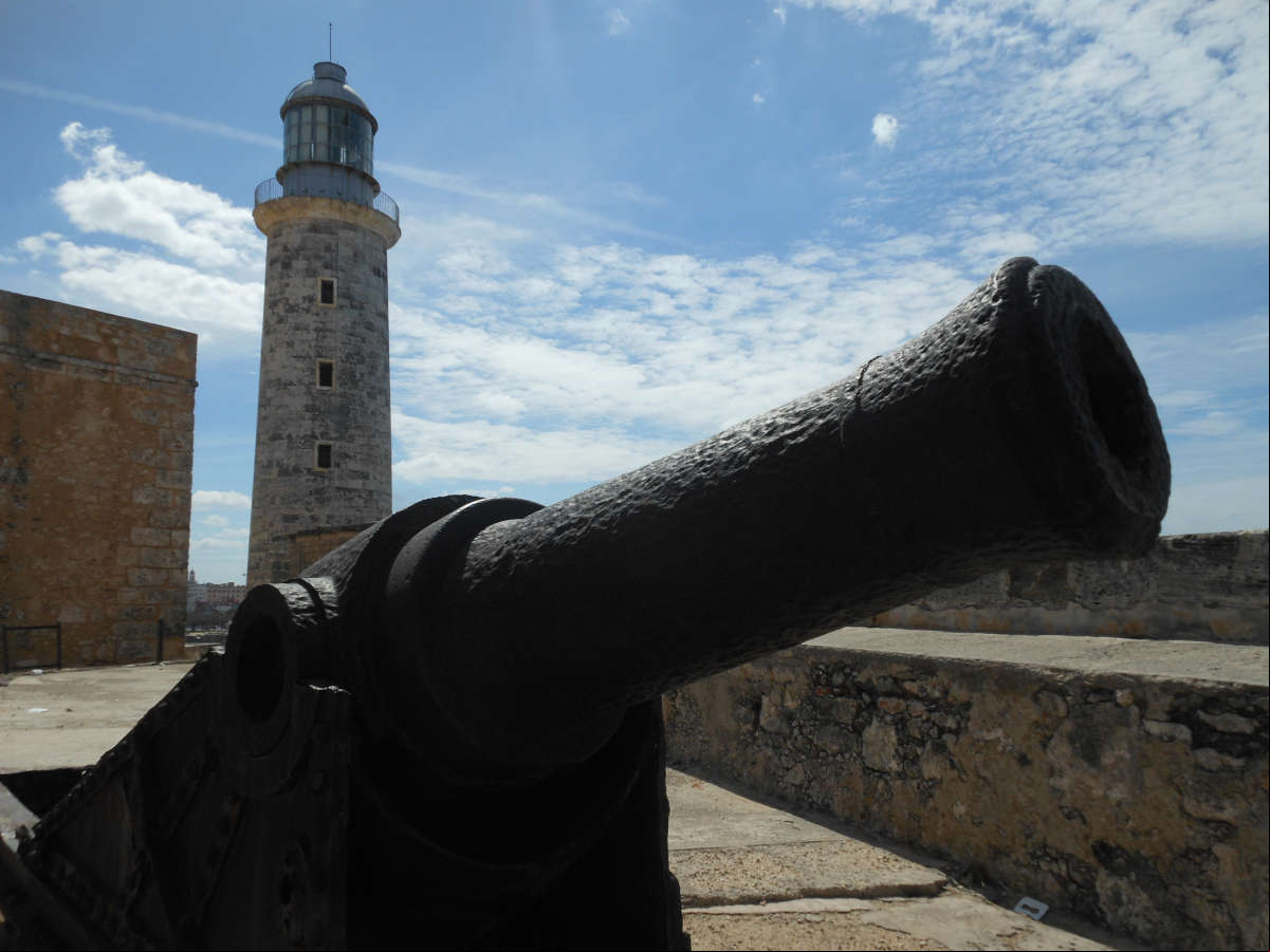 Antiguo cañón en el Castillo del Morro, al fondo la torre del faro Antiguo cañón en el Castillo del Morro, al fondo la torre del faro